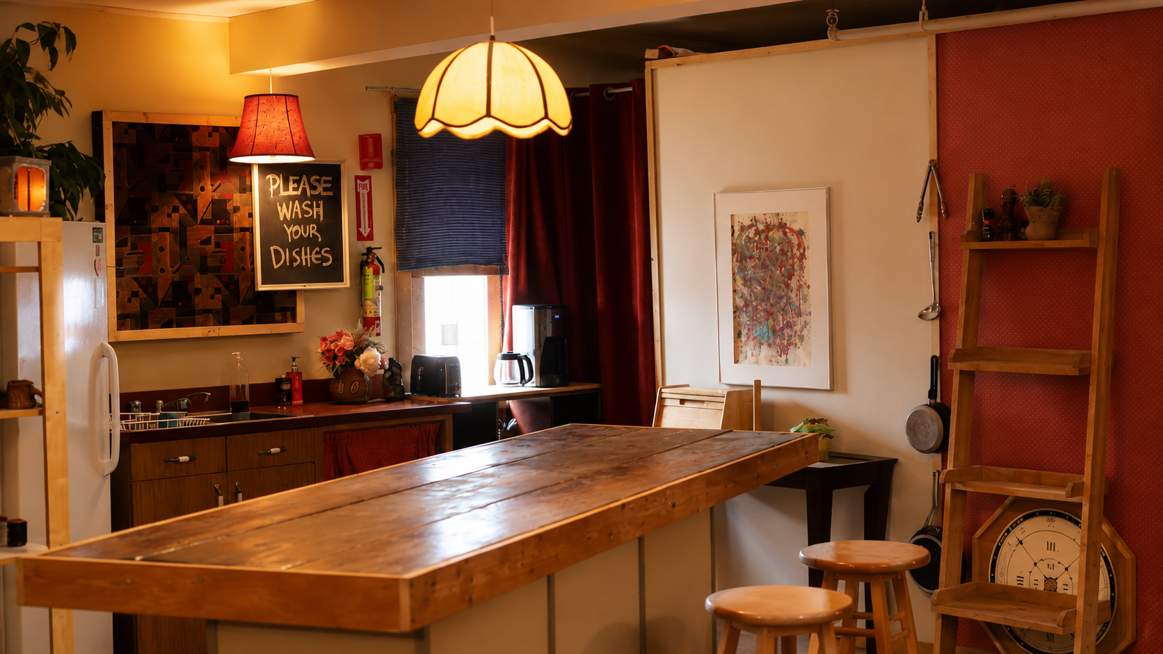 Shared kitchen and bar area with a long wood table, stools, and framed art